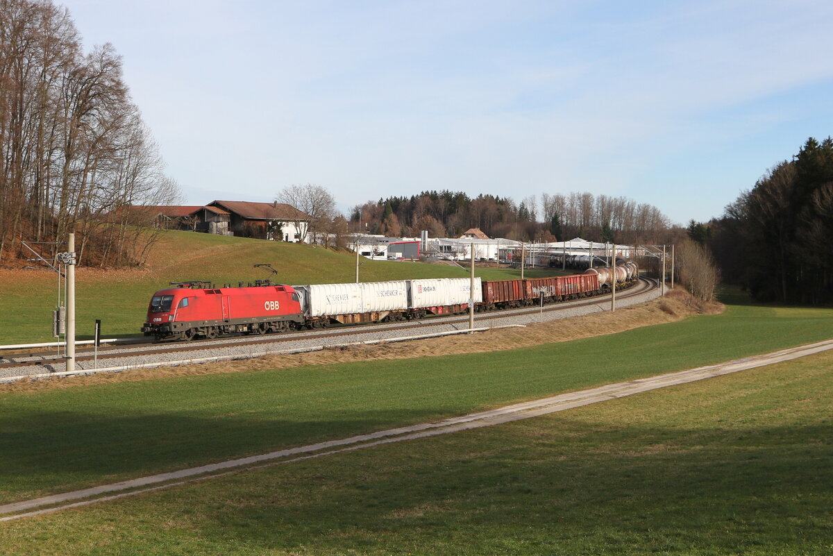 1116 135 war am 28. Dezember 2023 mit einem gemischten G�terzug bei Axdorf im Chiemgau in Richtung M�nchen unterwegs.