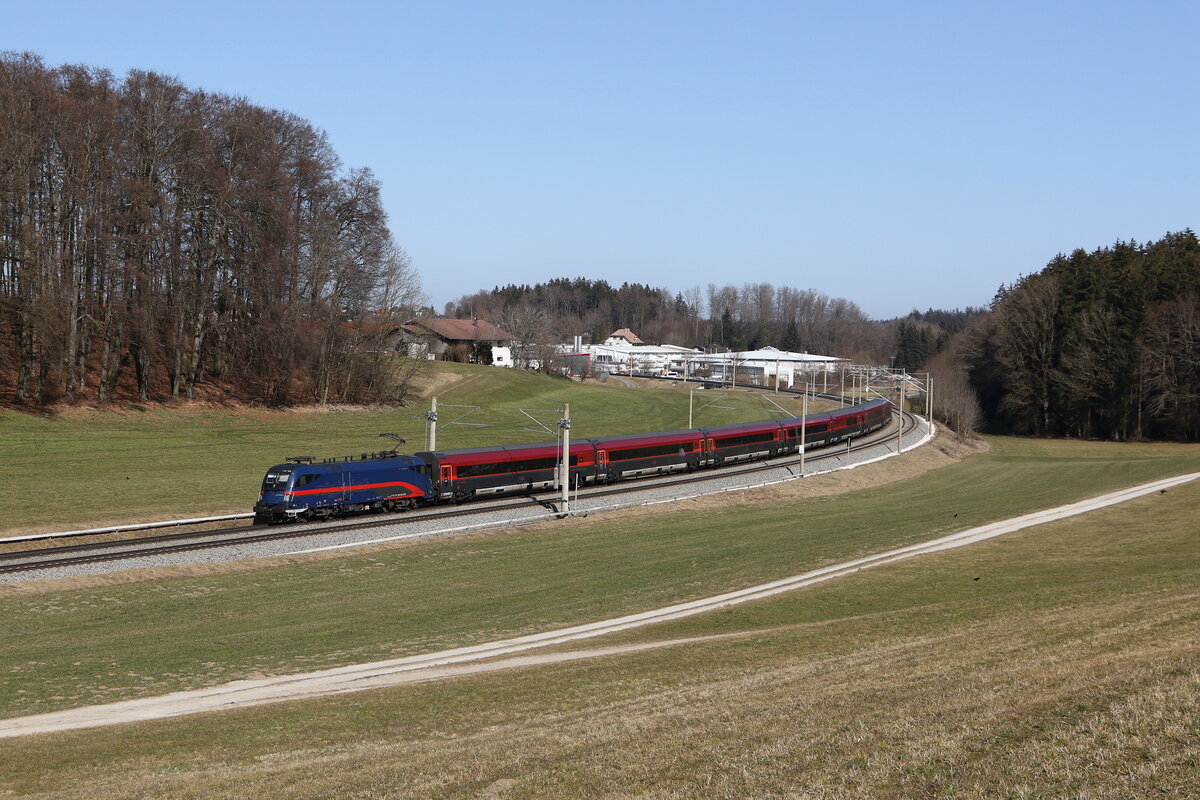 1116 195 mit einem  Railjet  aus Salzburg kommend am 7. M�rz 2025 bei Axdorf im Chiemgau.