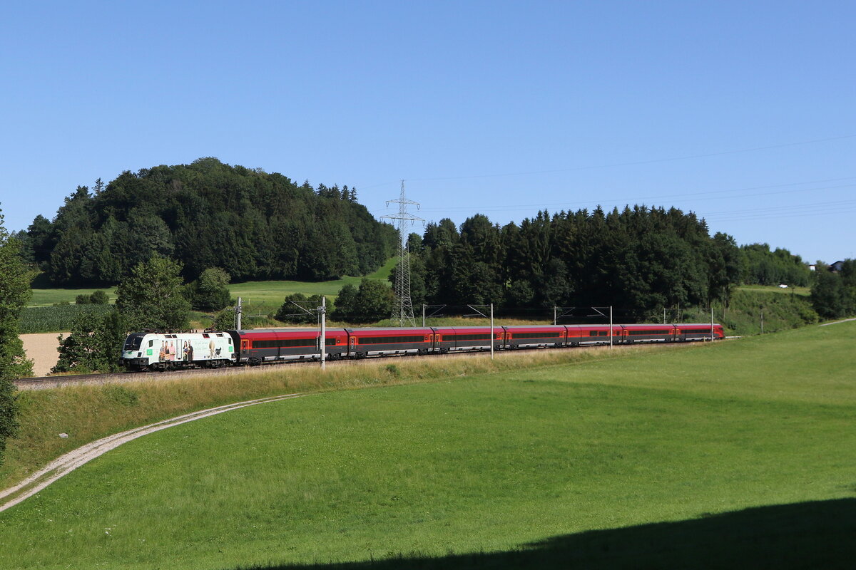 1116 231  BIO AUSTRIA II  mit einem  Railjet  aus Salzburg kommend am 19. Juli 2025 bei Vachendorf im Chiemgau.
