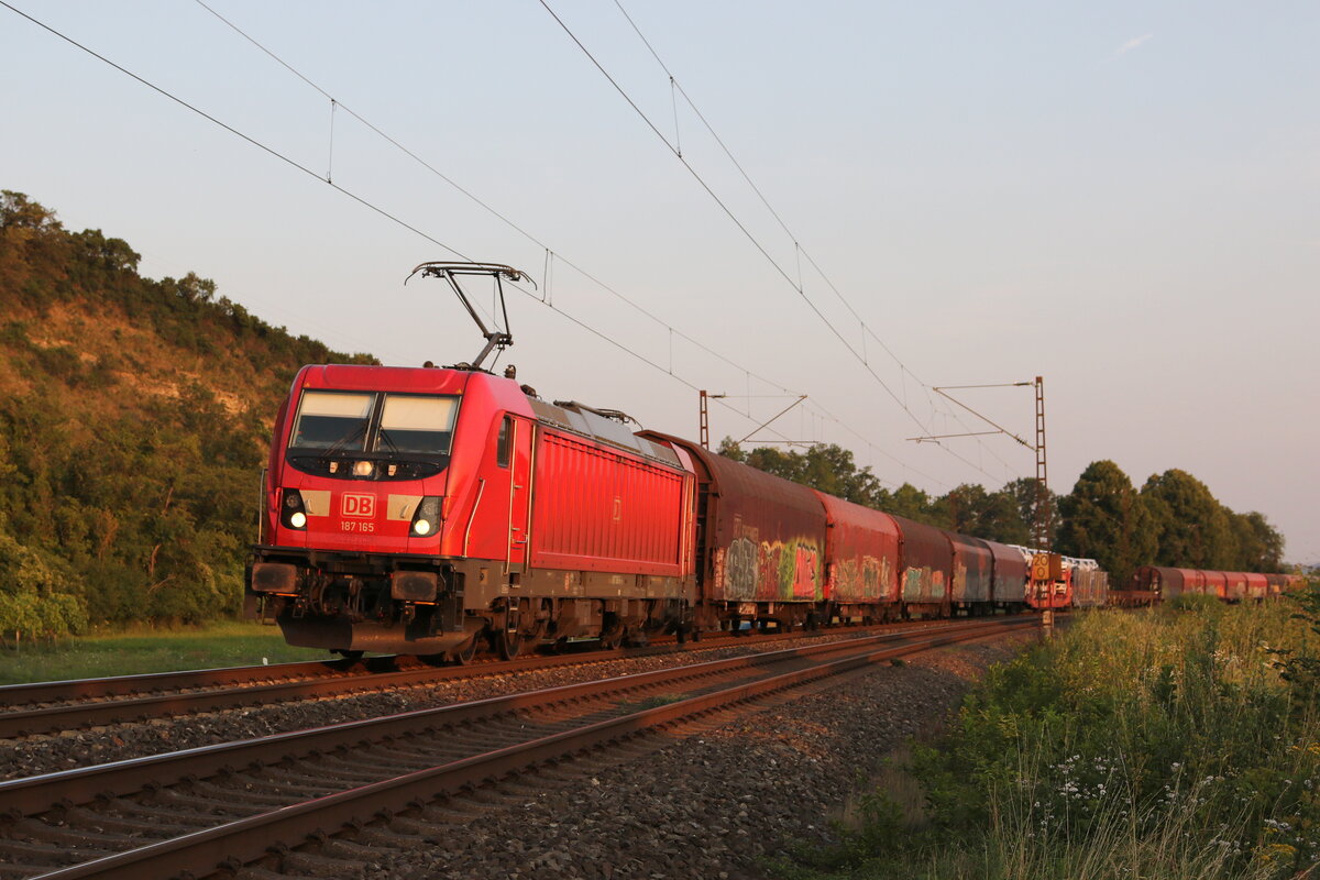 187 165 mit einem gemischten G�terzug im letzten Licht des 23. Juli 2021 bei Himmelstadt im Maintal.