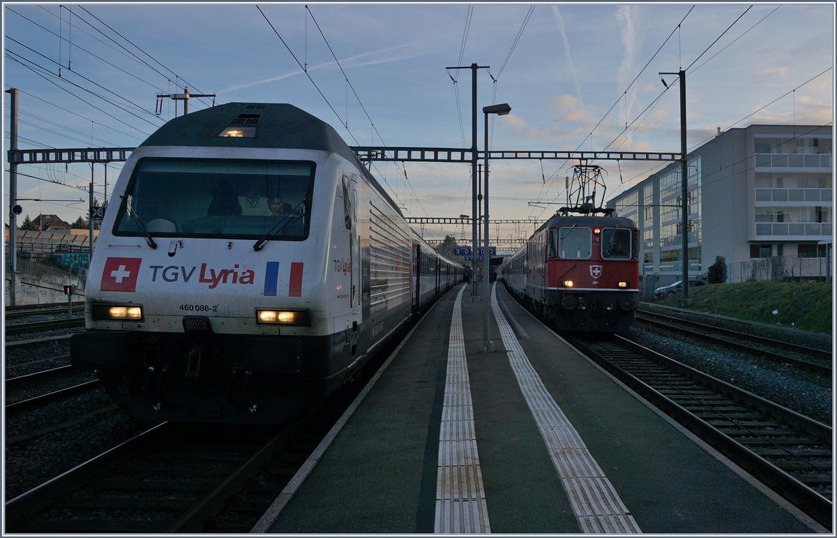 Der IR 1706 Brig - Genève Aéroport mit der SBB Re 460 086-2  TGV Lyria  wird von IR 1906 Sion Genève-Aéroprt mit der Re 4/4 II 11154 in Morges überholt.
22. Feb. 2017