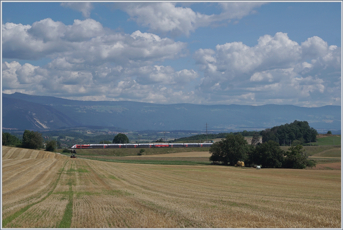Der TGV Lyria 9261 von Paris Gare de Lyon nach Lausanne oberhalb von Arnex auf der Fahrt durch die hügligen Jurasüdfuss Landschaft. 

25. Juli 2020