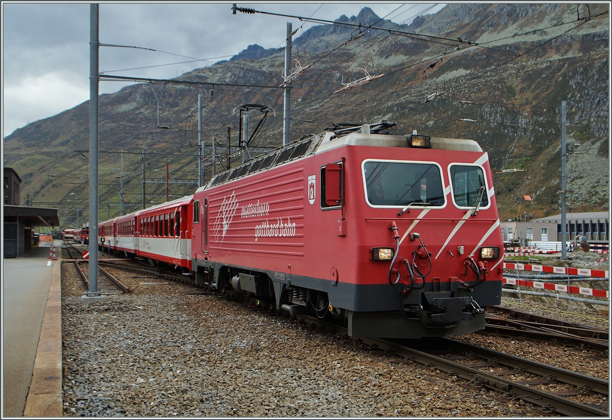 Die MGB HGe 4/4 103 mit einem Regionalzug nach Disentis im zur Zeit durch Umbauarabeiten etwas eingeschränkt zu benutzenden Bahnhofs von Andermattt .
10. Okt. 2014