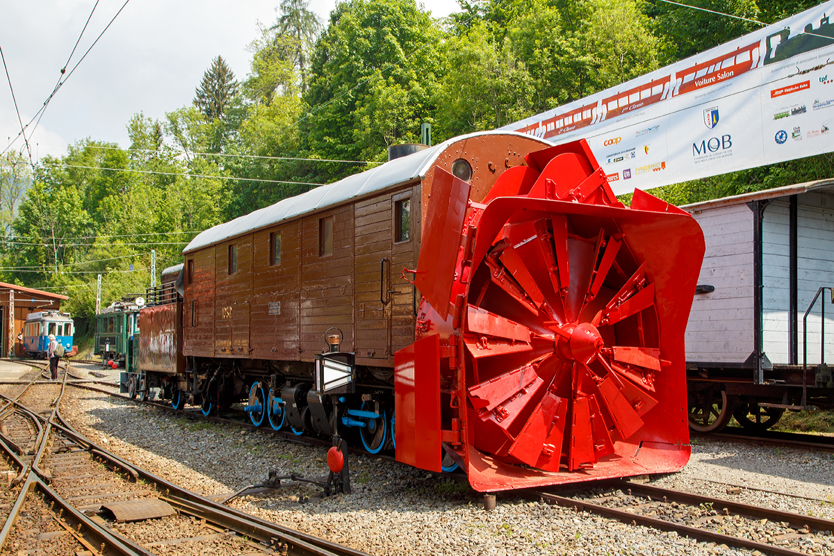 Die Selbstfahrende Dampfschneeschleuder R 1052 (ex (Berninabahn) BB R 1052, ex RhB R 14, ex RhB Xrot d 9214), der Museumsbahn Blonay-Chamby,hier am 19.05.2018 auf dem Museums-Areal der (BC) in Chaulin.

Die Schneeschleuder wurde 1912 von der Schweizerischen Lokomotiv- und Maschinenfabrik (SLM) unter der Fabriknummer 2299 als R 1052 für die Berninabahn gebaut, 1944 um bezeichnet in RhB R 14, 1954 um nummeriert in RhB Xrot d 9214 (Die Bezeichnung Xrot d setzt sich zusammen aus: X = Dienstfahrzeug, rot = rotierend, d = dampfgetrieben.), 1990 ging sie an die DFB, 1996 wurde sie  im Tausch gegen die ehemalige RhB R 12 von der B-C übernommen.

Dieses Fahrzeug wie auch das heute noch bei der RhB betriebsfähige Schwesterfahrzeug Xrot d 9213 (ex BB R 1051) sind dampfgetriebene Schneeschleudern mit eigenem Antrieb die für die Berninabahn (BB) gebaut wurden, die seit 1944 zur Rhätischen Bahn gehört. Im Gegensatz zu den bisher gebauten Fahrzeugen, auch der zwei Dampfschleudern der RhB-Stammstrecke, handelt es sich bei den beiden Bernina-Schleudern um selbstfahrende Fahrzeuge. Die Berninabahn entschied sich hierzu, weil in den engen Kurven mit nicht genügend hoher Kraft geschoben werden konnte und die Bahn selbst keine Fahrdraht-unabhängigen Triebfahrzeuge besaß. Die Schleudern wurden dennoch normalerweise mit Schiebetriebfahrzeugen eingesetzt, damit die gesamte Kesselleistung für die Dampfmaschine des Schleuderrades zur Verfügung stand.

Mit der Übernahme der Berninabahn durch die Rhätische Bahn (RhB) erhielten die beiden Schleudern die neuen Bezeichnungen R 13 und R 14, 1950 dann Xrot d 9213 und 9214. Die beiden Fahrzeuge befanden sich bis 1967 im regelmäßigen Einsatz und wurden danach durch modernere Schleudern ersetzt. Die Xrot d 9213 wird von der RhB im Heimatdepot in Pontresina weiterhin betriebsfähig gehalten. Sie wird heute vor allem zu touristischen Zwecken noch betrieben, und zwar im Rahmen so genannter Fotofahrten; zuweilen kommt sie aber auch noch bei der Räumung zum Einsatz.

Die Achsformel ist C'C', das Fahrzeug verfügen nach Bauart Meyer über zwei dreiachsige Triebdrehgestelle die durch vier Zylinder angetrieben werden, diese befinden sich unten mittig zwischen den Triebgestellen, darüber befindet sich der Antrieb für die Schneeschleuder, die von zwei weiteren Zylindern angetrieben wird. Der Durchmesser des Schleuderrads beträgt 2,5m, welches mit bis zu 170 U/min dreht und so bis zu drei Meter hohe Schneemassen beseitigen kann.
Gekuppelt ist die Schneeschleuder mit einem zweiachsigen Tender.

Die Xrot d 9214 wurde am 26. Januar 1968 zu einem einmaligen Großeinsatz auf der Arosabahn herangezogen. Geschoben von zwei ABDe 4/4 hatte sie die tiefverschneite Strecke zwischen Langwies und Arosa zu räumen und benötigte für den nur acht Kilometer langen Abschnitt acht Stunden.

TECHNISCHE DATEN:
Gebaute Anzahl: 2 (BB 1051, BB 1052)
Hersteller:  SLM
Baujahre:  1910 und 1912
Ausmusterung:  1967 (1052/ 9214), Die 1051 ist als RhB Xrot d 9213 betriebsfähig
Spurweite:  1.000 mm (Meterspur)
Achsformel: C'C'
Länge: 13.865 mm
Höhe: 3.800 mm
Breite: 2.800 mm, max. 3.600 mm
Gesamtradstand: 10.655 mm (inkl. Tender)
Kleinster befahrbarer Gleisbogen: R=45 m
Dienstgewicht: 45 t
Dienstgewicht mit Tender: 63,5 t
Höchstgeschwindigkeit:  35 km/h
Indizierte Leistung Antrieb: 221 kW
Indizierte Leistung Schneeschleuder: 368 kW
Treibraddurchmesser:  750 mm
Zylinderanzahl: 4 für Antrieb und 2 für Schneeschleuder
Kesselüberdruck: 14 bar
Wasservorrat:  7 m³
Kohlevorrat:  4 t 
