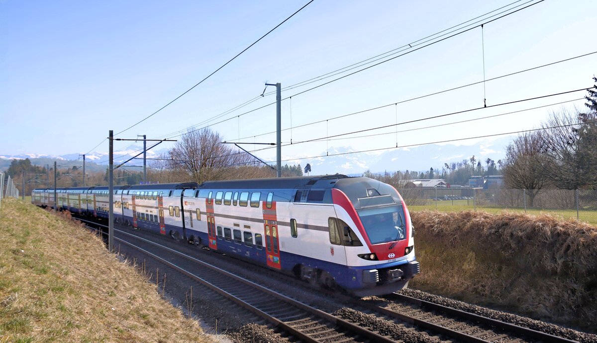 Die Strecke Uster - Wetzikon - Rüti ZH - Rapperswil: Im Anblick der Alpen kommt Flirt 511 033 als S5 von Pfäffikon SZ her mit Ziel Uster, Zürich, Affoltern am Albis und Zug. Bubikon, 5.März 2025   