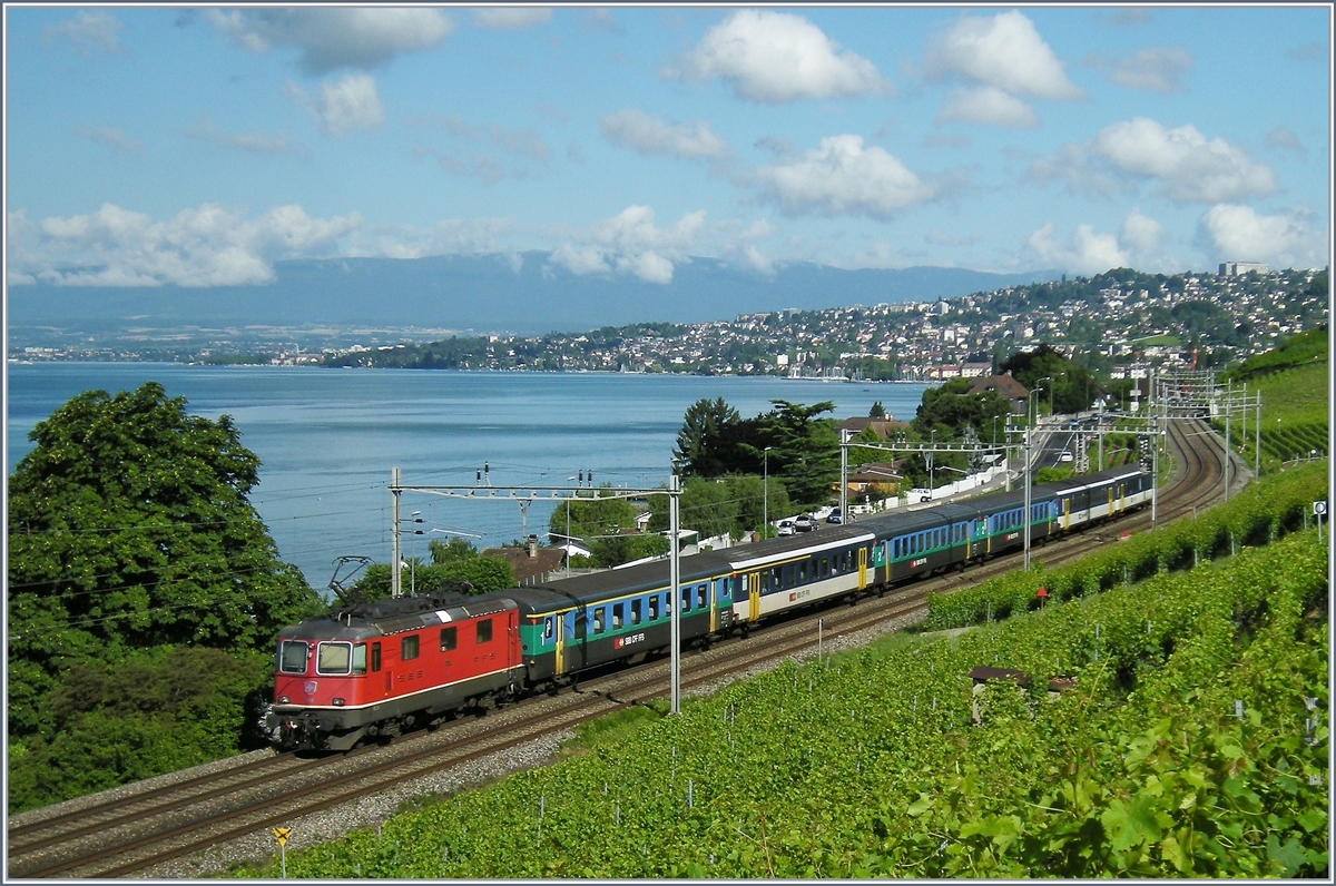 Eine SBB Re 4/4 II fährt mit einer bunten Wagengarnitur bestehend aus EW I und EW II bei Cully Richtung Lausanne.
4. Juli 2008