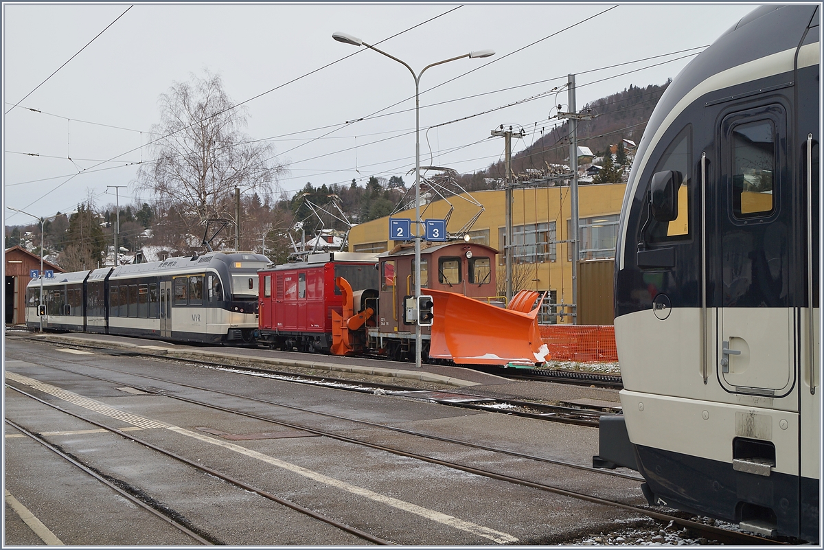 Inmitten moderner MVR SURF ABeh 2/6 steht in Blonay die CEV HGe 2/2 N° 1 mit der Xrot 91 und wartet nach der Schneepflugfahrt auf den Les Pléiades und zurück auf ein freies Gleis für die Fahrt in Dépôt. 

27.Febraur 2020
