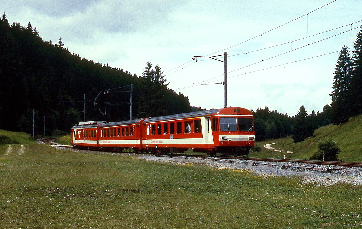 Mit dem Steuerwagen ABt 713 voraus ist ein BDe 4/4 II der CJ im Sommer 1997 in der Nähe der einsam gelegenen Station La Combe unterwegs 