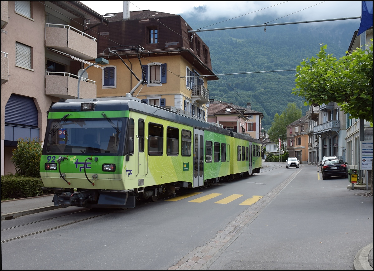 Ortsdurchfahrt in Bex. Der TPC-Triebwagen 92 nutzt die falsche Stra�enseite, so wird der geneigte Autofahrer ohne Chance auf Widerstand zum englischen Autofahrer. Juli 2017.