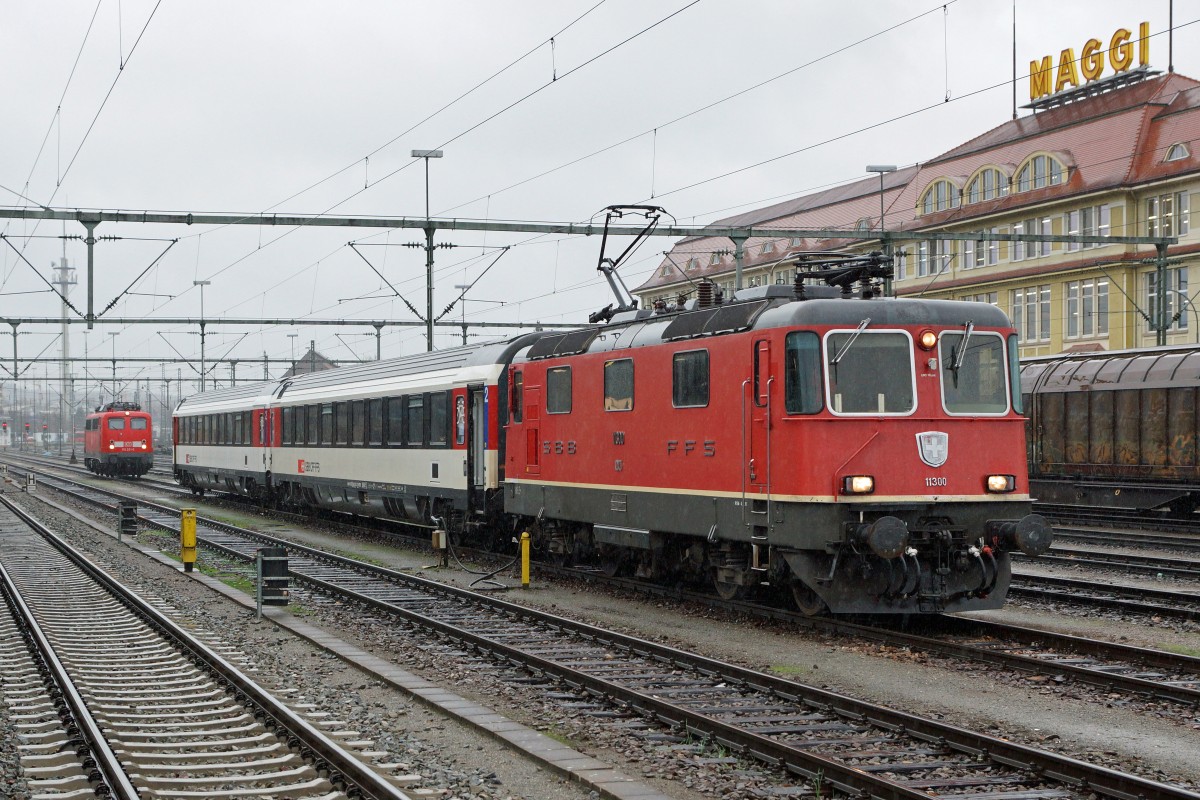 SBB/DB: Fotografieren in Singen am 20. November 2015 trotz starkem Wind und Dauerregen. Die 115 261-0 und die Re 4/4 mit zwei Bpm warteten gemeinsam auf dem selben Streckengeleise auf ihre n�chsten Eins�tze. Da der IC aus Stuttgart nur aus drei 3 Bpm besteht, wurde dadurch die Weiterfahrt bis Z�rich-HB um zwei Wagen verst�rkt. 
Foto: Walter Ruetsch 