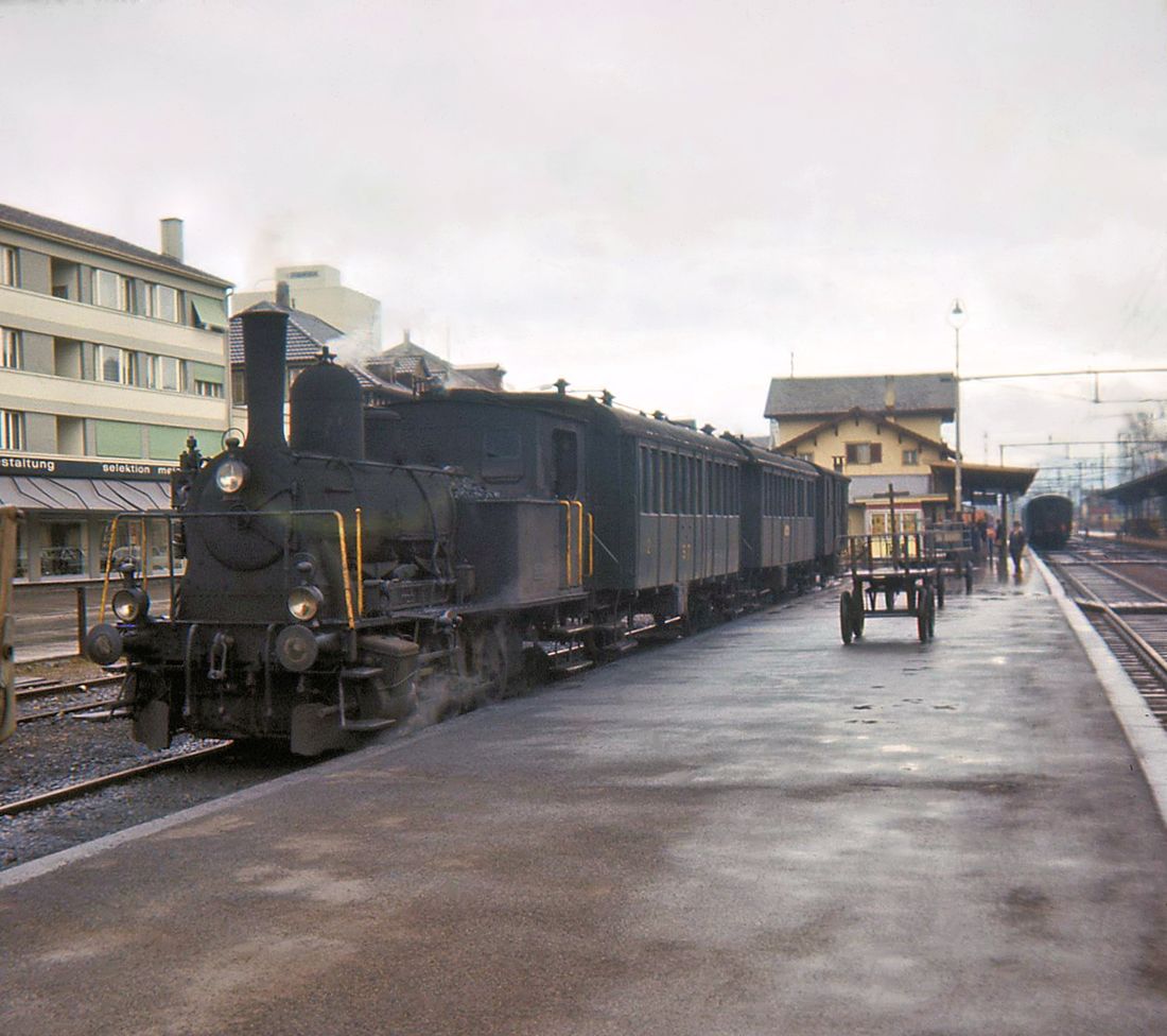 Sursee Triengen Bahn (Regelbetrieb): Diese knapp 9 km lange Strecke stellte den Regelbetrieb am 26.September 1971 ein. Hier wartet ein fahrplanm�ssiger Zug in Sursee auf Abfahrt. Der Zug besteht aus der ehemaligen SBB-Dampflok ST 5, einem Erst- und Zweitklasswagen, einem Zweitklasswagen, und einem Gep�ckwagen. 21.M�rz 1965. 