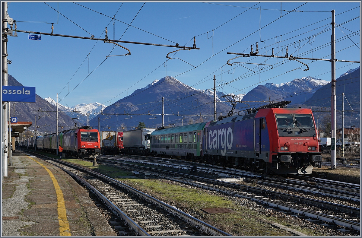 Während die SBB Re484 007 mit ihrer RoLa Domodossola Richtung Novara verlässt, ist die Re 484 011 noch mit Rangieraufgaben für  ihre  RoLa beschäftigt.
11. März 2017