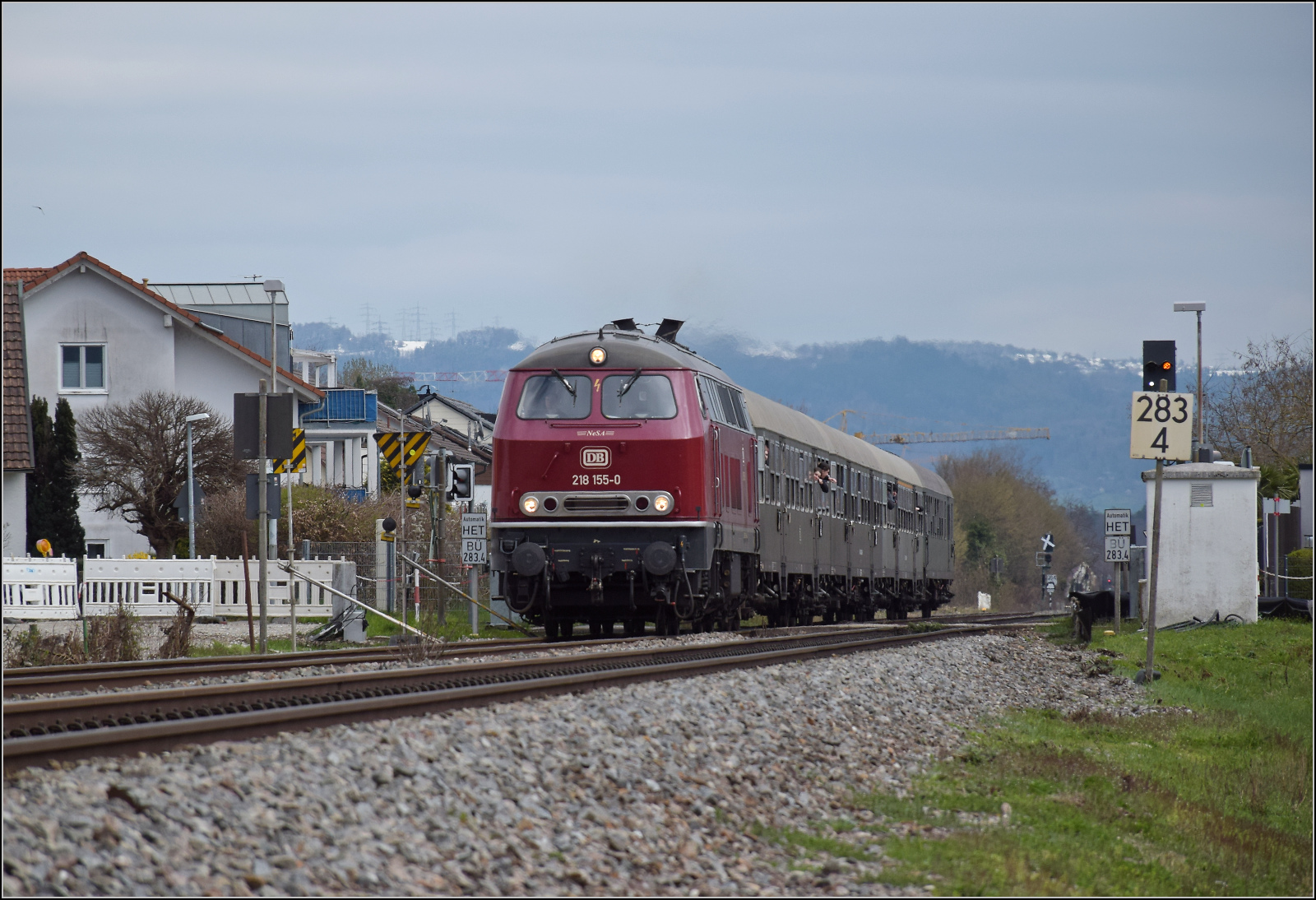 Dieselabschiedsfahrt am Hochrhein. 

218 155 fährt zum zweiten Mal mit vielen geneigten Fahrgästen im Zug der EFZ nach Basel. Die Lok wie aus der Märklinschachtel, den frisch verschneiten Hotzenwald im Rücken geht es hier durch die Baustelle für den neuen Haltepunkt Warmbach. März 2026.