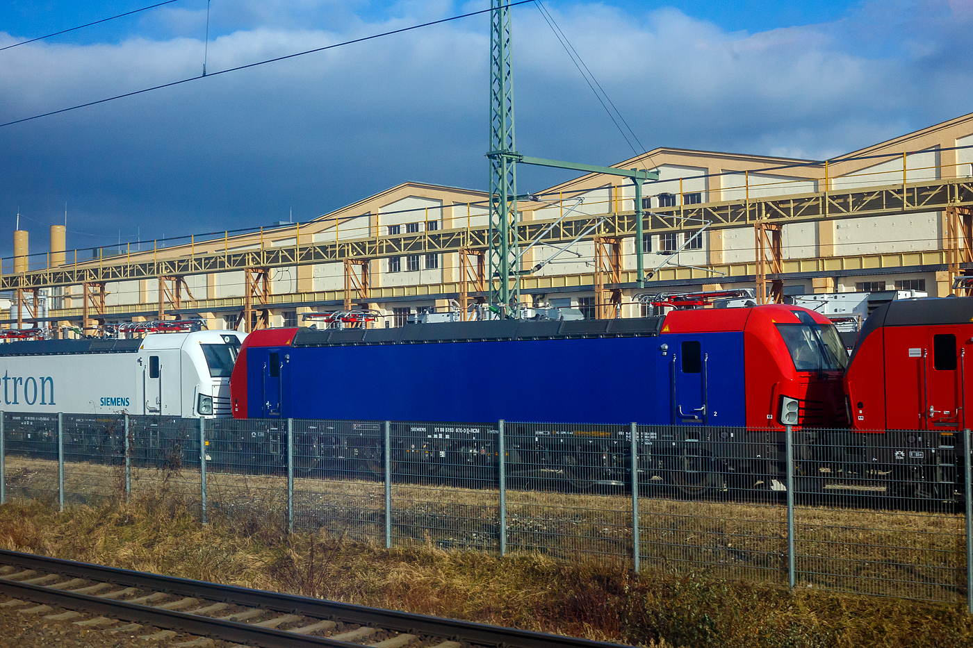 Frisch aus der Produktion, noch nicht ausgeliefert und noch ohne SBB Cargo AG Werbung, die SIEMENS Vectron AC – 193 070-0 (91 80 6193 070-0 D-RCM) für die RCM Rail Care and Management GmbH (München), steht am 13 Januar 2025 auf dem Werksgleisen vor den Werkshallen der SIEMENS Mobilitiy in München-Allach. Aufnahme aus einem ICE heraus.

Die Wechselstromlok (AC 15 kV 16,7 Hz und AC 25 kV 50 Hz) vom Typ SIEMENS Vectron AC wurde 2024 von Siemens Mobilitiy in München-Allach unter der Fabriknummer 23692 gebaut. Sie wurde in der Variante Vectron AC B48 ausgeführt und hat so die D / A / CH Zulassungen (Deutschland, Österreich und die Schweiz). Diese Vectron AC B48 besitzen auch nur 2 Stromabnehmer, jeweils einen mit breiter und schmaler Wippe. Im März 2025 wurde die Lok an die LokRoll3 AG, Luzern (eingestellt über die Rail Care and Management GmbH, Starnberg) geliefert und von dieser, für die nächsten 8 Jahre,  an die SBB Cargo AG vermietet. 
