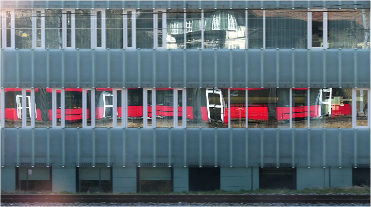 Mit Peter unterwegs in Bern - 

Nach der Abfahrt am Bahnhof Gümligen spiegelt sich Tramlink 928 im Fensterband des jenseits der Bahngleise liegenden Bürohauses. Die weiß gerahmten Türen des Trams korrespondieren mit den Öffnungsflügeln der Fensterbänder des Hauses.

07.03.2025
