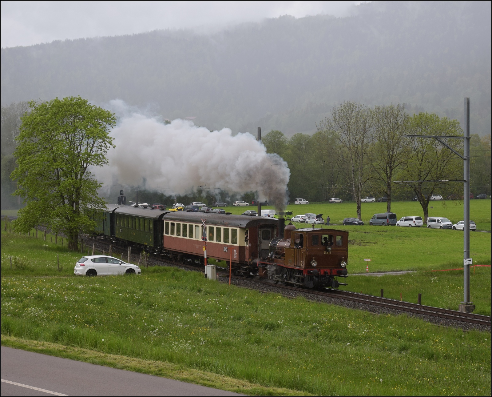 Vapeur Val-de-Travers: Train  Au fil de l'Areuse .

E 3/3 8511 umfährt das Landhaus Le Marais zwischen Môtiers und Couvet. Mai 2023.