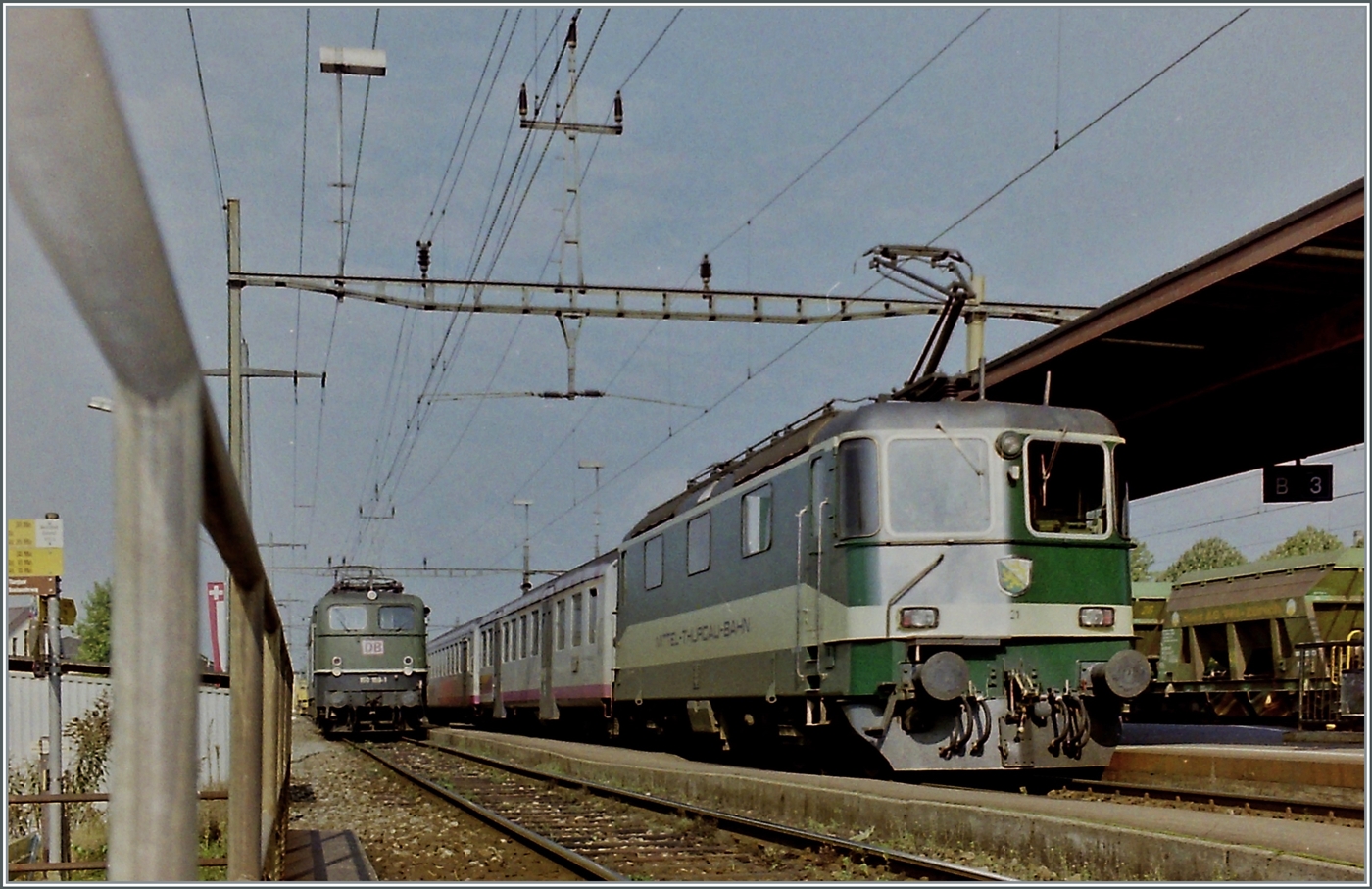 Während in Weinfelden im Hintergrund  die Kornwestheimer die DB 150 169-1 mit einem Öl-Zug auf die Abfahrt wartet, wendet die MThB Re 4/4 II 21 mit einem Pendelzug nach Wil.

Später erhielt die MThB Re 4/4 II 21 die SBB Nummer 11172, welche von der 1978 verunfallten und in der Folge ausrangierten Re 4/4 II 11172 nicht mehr besetzt war. 

Analogbild vom 26. Sept. 1996
