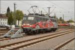 Die exotische 115 509-2 mit der Autozugwerbung in Diensten der Gäubahn-ICs wartet in Singen auf den nächsten Einsatz.
