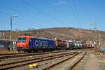 Die Re 482 014-8 (91 85 4482 014-8 CH-SBBC) der SBB Cargo AG fährt am 24.03.2021, mit einem HUPAC-KLV/Container-Zug durch Niederschelden in Richtung Köln.

Die TRAXX F140 AC1 wurde 2002 von Bombardier in Kassel unter der Fabriknummer 33539 gebaut und an die SBB Cargo AG geliefert. Sie hat die Zulassungen und Zugbeeinflussungssysteme für die Schweiz und Deutschland. Zurzeit ist sie an die SBB Cargo International AG vermietet.

Obwohl die Baureihe Re 482 der SBB Cargo grundsätzlich von der Baureihe 185 abgeleitet ist, gibt es doch kleine Unterschiede. Wie bei der deutschen Baureihe 185 handelt es sich bei der Re 482 um eine Zweisystemlokomotive für 15 kV, 16 2/3 Hz und 25 kV, 50 Hz. Zugelassen sind die Lokomotiven für das deutsche und Schweizer Bahnnetz. Im Gegensatz zu den Loks der Baureihe 185, die ab Werk erst ab etwa 185 050 mit einer Leistung von 5.600 kW ausgeliefert wurden, kamen die Loks der Bauart Re 482 bereits mit der erhöhten Leistung zur SBB Cargo.

Weiterhin verfügen alle Re 482 über vier Stromabnehmer, von denen jeweils zwei für die deutsche und zwei für die schweizerische Oberleitung ausgelegt sind. Im Bereich der Sicherungstechnik verfügen die Loks über die deutschen Systeme Indusi, LZB 80 und PZB 90 und die Schweizer Systeme Signum und ZUB 262. Zusätzlich sind im Lokkasten Kameras eingebaut, die Rückspiegel ersetzen sollen. 
Jedoch wurden die Loks 482 010 bis 482 014 (wie diese hier) ohne  Schweizpaket  ausgeliefert und waren erst nur für Deutschland zugelassen. Bei diesen Loks fehlten die Stromabnehmer mit Schweizer Schleifstück, das Sicherungssystem Integra und die bereits erwähnten Kameras. Diese fünf Loks wurden aber alle Ende 2003 auf das  Schweizpaket  umgebaut.

Mit der zweiten Bauserie der Re 482, die ab 482 035 gab es einige Veränderungen an der Lok. Zudem sind diese nun TRAXX F140 AC2. Der gesamte Lokkasten wurde neu gestaltet und auf sein Crashverhalten optimiert. Ebenso erhielten die Fahrzeuge nun neue Puffer, die wiederum mit dämpfenden Elementen verschraubt sind.

Auf Anhieb sichtbar sind die Unterschiede zwischen der ersten und der zweiten Baureihe: Bei der zweiten Bauserie (TRAXX F140 AC2) ist der Übergang zwischen der Dach- und der Stirnfläche wesentlich stärker geknickt als vorher. Weiterhin sind die bisher auf verschiedenen Ebenen angebrachten Griffstangen an der Lokfront bei der zweiten Baureihe nun auf gleiche Höhe direkt unter die Führerstandsfenster gerückt. Unter den Stirnfenstern befindet sich nun eine Klappe, in der die Klimageräte für den Führerstand untergebracht sind. Zudem verfügen einige Re 482 der zweiten Serie (TRAXX F140 AC2) teilweise über Zulassungen für Österreich. 

TECHNISCHE DATEN:
Spurweite: 1.435 mm (Normalspur)
Achsfolge: Bo'Bo'
Dienstgewicht: 85 t
Länge über Puffer: 18.900 mm
Drehzapfenabstand: 10.440 mm
Dauerleistung: 5.600 kW
Höchstgeschwindigkeit: 140 km/h
Fahrleitungsspannung:15000 V, 16.7 Hz ~
Zulassungen: CH / D (Zweite Serie teilweise auch A)
