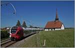 Auf dem Weg von Fribourg nach Bulle fährt der TPF RABe 527 192 an der hübschen Chappelle de Vaulruz vorbei.