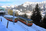 Bergbahn Lauterbrunnen - Mürren: Triebwagen 21 verlässt Grütschalp, während Wagen 31 (ex-ASm 102 ex-OJB 82) daneben abgestellt ist.